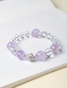 Vista detallada de pulsera de cuentas de amatista lavanda y cristal blanco con loto