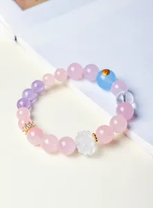 Vue rapprochée d'un bracelet en perles de cristal avec breloque lotus blanc
