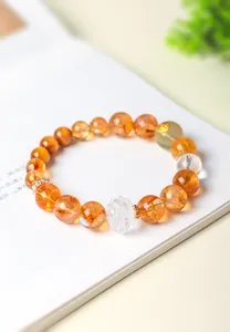 Gros plan d'un bracelet en perles de citrine naturelle avec un lotus en cristal facetté.