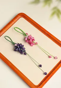 Detail view of exquisite purple and pink chalcedony grape charms on a wooden tray