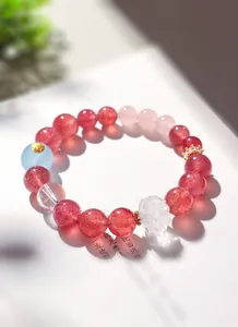 Détail d'un bracelet en perles de quartz fraise naturel et cristal de roche lotus.