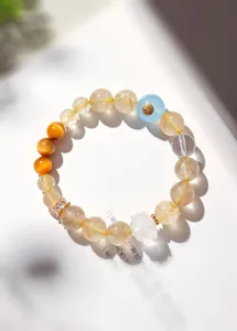 Détail de perles de quartz rutilé naturel avec une fleur de lotus en cristal de roche sculptée