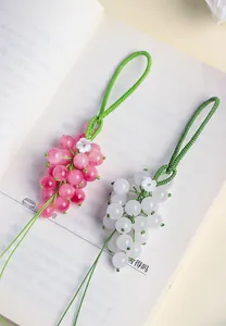 Detailed macro shot of pink and white chalcedony grape pendants with green cord