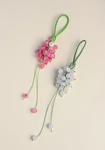 Detail of handcrafted chalcedony grape pendants with elegant green braided cord strap