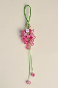 Pink chalcedony grape charm with green braided cord and small white shell flower