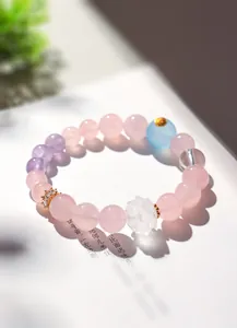 Gros plan d'un bracelet en quartz rose et améthyste avec lotus en cristal