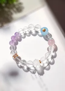 Vue macro de perles de quartz clair et d'un lotus en cristal sculpté sur le bracelet