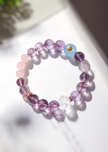 Gros plan détaillé d'un bracelet en perles d'améthyste naturelle avec un pendentif en lotus.