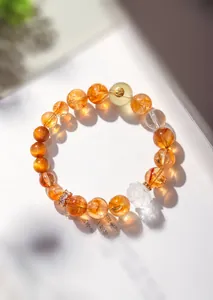 Gros plan d'un bracelet en quartz rutile doré naturel avec lotus en cristal sculpté