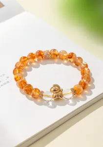 Dettaglio ravvicinato di un bracciale in citrino con ciondolo a forma di cavallo dorato