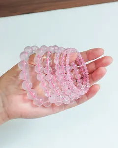 Vue détaillée de bracelets en perles de quartz rose naturel translucide en main