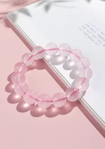 Vue détaillée de perles de quartz rose naturel translucide sur un bracelet élastique