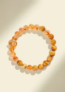 Macro view of natural yellow tower crystal and gold tiger eye stones on a beaded bracelet