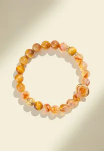 Close-up of natural yellow rutilated quartz and tiger eye bead bracelet with gold accents.