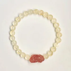 Vue détaillée d'un bracelet en perles de quartz jaune avec un charme pixiu rouge sculpté