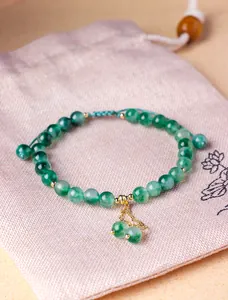 Macro view of 6mm natural green water grass chalcedony beaded bracelet with gold charm