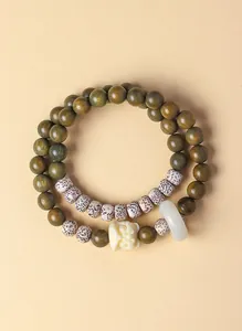 Detailopname van dubbele groene sandelhout armband met Bodhi-zaden en leeuwenbedel