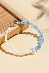 Close-up of aquamarine crystal bracelet with freshwater pearl and S925 silver.