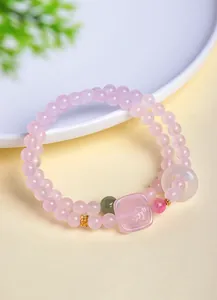 Gros plan sur un élégant bracelet en quartz rose avec un pendentif en jade Zhagilamu sculpté