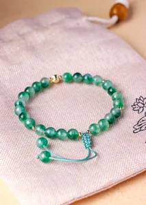Detailed macro shot of 6mm natural green aquatic agate beads on a woven bracelet.