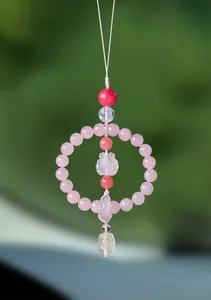 Close-up of natural rose quartz car hanging ornament featuring a carved crystal fox