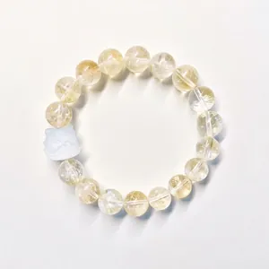 Gros plan d'un bracelet en citrine naturelle avec un pendentif sculpté bleu clair