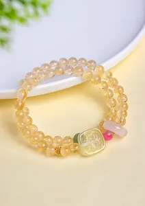 Vue rapprochée d'un bracelet en perles de citrine avec breloque carrée et pierres colorées.