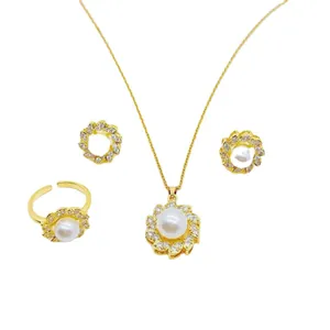 Vista dettagliata di un set di gioielli con perle e fiori dorati, collana, anello e orecchini