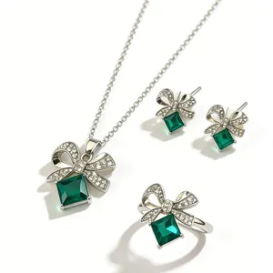 Vista dettagliata del set di collana, orecchini e anello con fiocco verde lusso