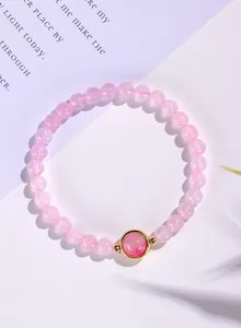 Gedetailleerd bovenaanzicht van roze kristallen kralenarmband met gouden middensteen.