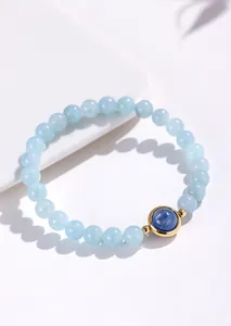 Hoogwaardige detailweergave van een aquamarijn kralenarmband met goudgezette blauwe steen