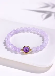 Gedetailleerde weergave van lavendel amethist kralenarmband met gouden accent
