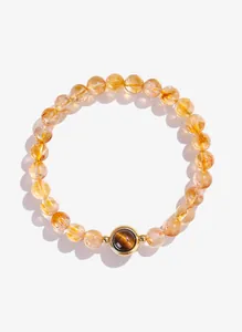 Detail van een natuurlijke gele kristallen armband met een centrale tijgeroogsteen