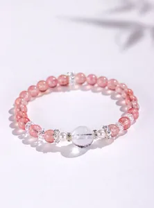 Detailansicht eines natürlichen Erdbeerquarz-Armbands mit Perlen und Bergkristall.