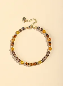 Detailaufnahme eines Naturstein-Armbands mit Tigerauge und gelben Kristallperlen