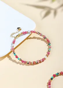 Detailaufnahme eines Perlenarmbands aus Rhodonit und Süßwasserperlen mit Blattschatten