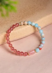 Detail eines Perlenarmbands mit Erdbeerquarz, Amazonit und rosa Kristallzentrum.