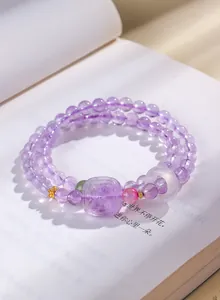 Détail macro du bracelet en perles d'améthyste violette avec anneau en agate blanche