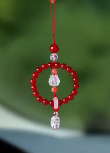 Close-up detail of a red agate car hanging pendant featuring a carved fox charm