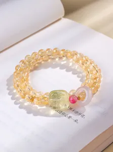 Vue détaillée d'un bracelet en cristal jaune avec pendentif en jade sur un livre