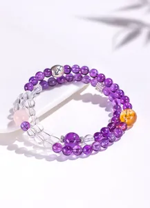 Detailaufnahme eines doppelreihigen Amethyst- und Quarzkristall-Armbands mit Tierkreiszeichen