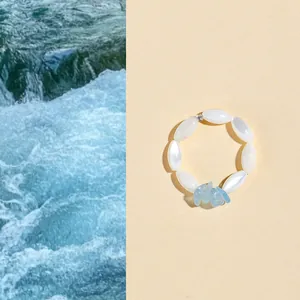 Summer aquamarine crystal bracelet with white beads on a split water background