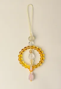 Detailed macro view of natural rose quartz and citrine crystal car hanging ornament.