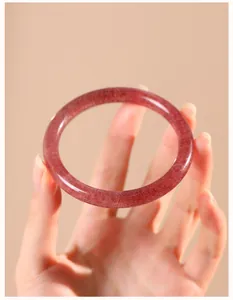 Detailopname van een natuurlijke aardbeikristallen armband in duivenbloedrood.
