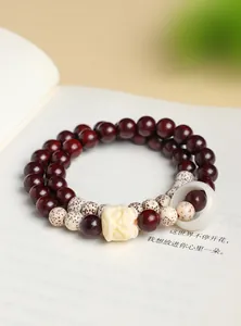 Close-up van dubbele armband van sandelhout met ster-maan Bodhi-kralen en leeuwenkop