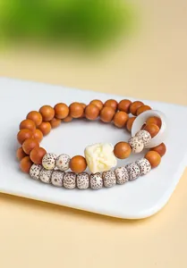 Detailopname van een traditionele dubbellaagse armband van sandelhout en Bodhi-zaden.
