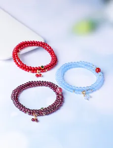 Gedetailleerd overzicht van drie meerlagige natuurlijke kristallen kralenarmbanden in rood en blau