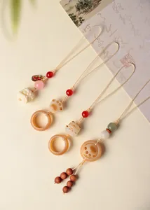 Vue macro détaillée de charms artisanaux en graines de Bodhi et agate pour sacs