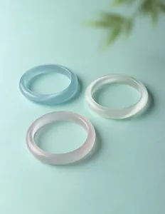 Gedetailleerde opname van drie elegante doorschijnende kattenoogsteen armbanden.