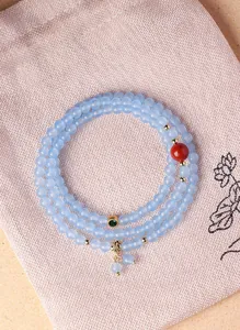 Elegant detail van blauwe kristallen multi-wikkelarmband op een linnen sieraden geschenktasje